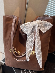 Brown canvas tote bag with yellow embroidery text and lace bow decoration for women