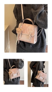 Close-up of pink glitter crossbody bag with bow relief and plush bear charm detail