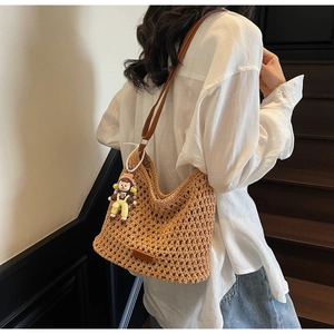 Detail view of khaki woven tote bag with honeycomb texture and leather strap