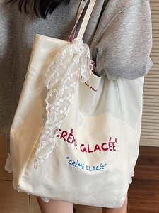 Minimalist canvas tote bag with Crème Glacée embroidery and lace details on shoulder strap