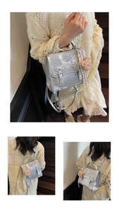 Detail view of silver shiny backpack with bow, star rhinestones and plush bear charm