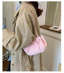 Détail d'un sac seau rose pâle inspiré du ballet avec un nœud délicat sur un mannequin
