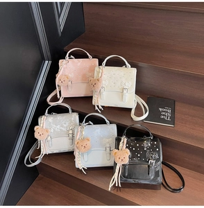 Detail view of stylish square backpacks in five colors displayed on wooden stairs