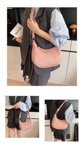 Detail of pink pleated handbag with vertical ruffles and stylish knotted strap design
