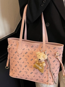 Sac cabas en cuir rose avec motifs d'ours et breloque porté par un mannequin