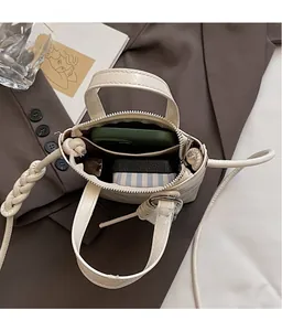Internal view of cream mini bucket bag showing dual compartments for phone and wallet