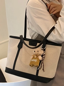 Minimalist large canvas tote bag with black leather trim and cute bear charm accent
