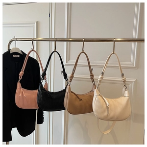 Close-up of pleated handbag colors including pink, black, camel and beige styles