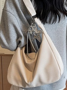 Schicke beige Umhängetasche in Halbmondform mit Fischgrätmuster und süßem Anhänger