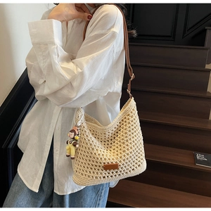 Close-up of bohemian woven tote bag featuring cotton net design and brown leather straps