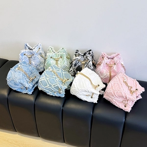 Detail of frayed edge denim bucket bags with quilted patterns and pearl chain drawstring