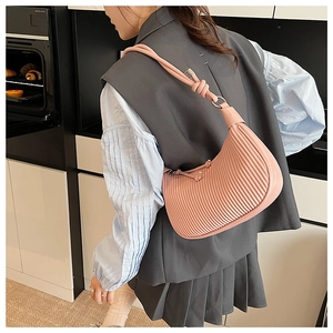 Detail of pink pleated hobo bag with knotted strap and textured synthetic leather surface