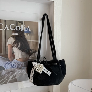 Détail du sac seau en velours noir avec bordure en dentelle et pendentif cœur en perles