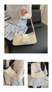 Gros plan du sac sous le bras beige tressé avec nœud décoratif en cuir et texture