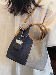 Stylish patchwork denim bucket bag with brown leather handles and silver lock pendant accessory