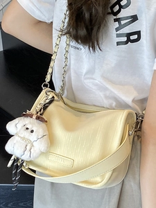 Minimalist creamy yellow crossbody bag with chain strap and cute puppy pendant accessory