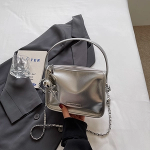 Detailansicht der silbernen Mini-Tasche mit Kettenriemen und Ballonhund-Anhänger