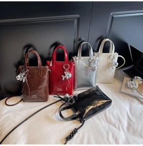 Mini high-shine bucket bags in five colors with a silver balloon dog charm detail