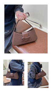 Gros plan d'un sac à bandoulière tressé marron avec détail de nœud style baguette