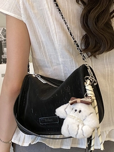 Chic black nylon shoulder bag with silver chain strap and a white puppy plush charm
