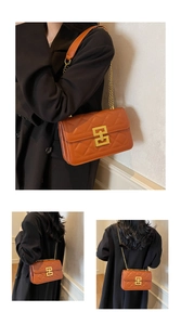 Détail d'un sac à bandoulière matelassé marron avec fermoir doré et bandoulière chaîne
