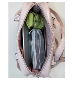 Top-down close-up showing the spacious pink backpack interior with tablets and umbrellas
