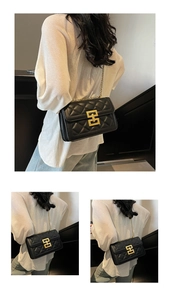 Détail d'un sac bandoulière en cuir matelassé noir avec fermoir doré et chaîne