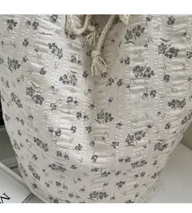 Detailed macro view of soft floral fabric texture with purple flowers and drawstring