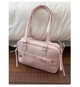 Pink JK style bag featuring front bow decoration and heart-shaped metal pendant detail