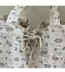 Close-up of floral canvas tote bag featuring purple flower print and cotton drawstring detail
