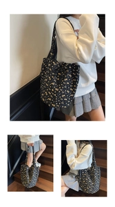 Multiple views of a black floral canvas tote bag with drawstring closure and shoulder straps