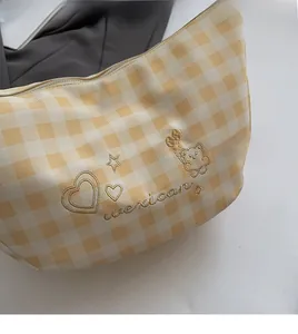Gros plan du sac cabas vichy jaune avec broderie dorée d'ours et de cœurs