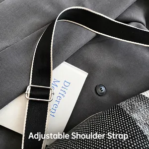 Detalle de la correa tejida ajustable con hebilla de metal plateado en un bolso de cuadros