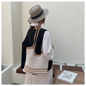 Detail of hollow woven cotton mesh tote bag in beige and khaki for summer beach vacations