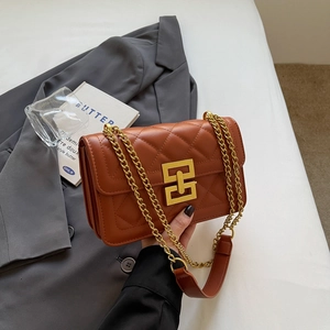 Détail d'un sac en cuir matelassé marron avec fermoir doré et bandoulière en chaîne chic