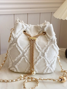White denim bucket bag with frayed quilted pattern, gold chain strap and pearl details