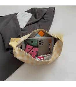 Intérieur spacieux du sac à damier jaune montrant la capacité pour tablette et objets