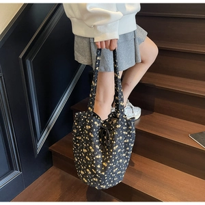 Detail view of floral canvas tote bag with drawstring closure on wooden stairs