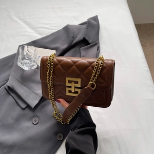 Détail d'un sac à bandoulière en cuir matelassé marron foncé avec fermoir doré élégant