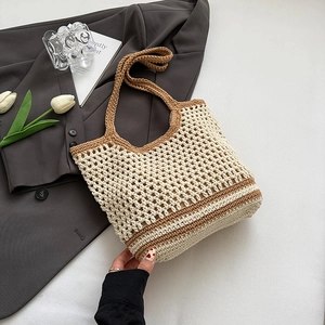 Detail of hollow mesh cotton weave bag featuring brown strap on grey suit background