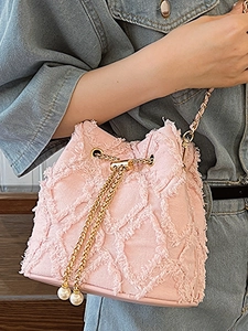 Pink frayed denim bucket bag with quilted stitching, pearl charms, and gold chain strap