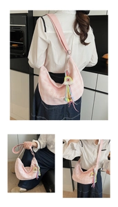 Détail du sac hobo à carreaux roses avec broderie cœur et breloque arc-en-ciel colorée