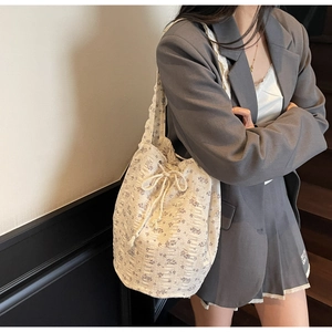 Detailed shot of floral canvas drawstring bucket bag with purple flower patterns