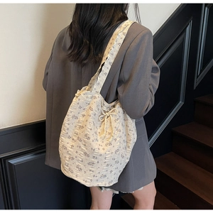 Detail of floral canvas tote bag featuring lavender patterns and drawstring closure