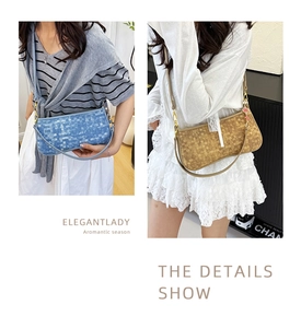 Detail showing woven texture underarm bag with metal clasp and strawberry charm