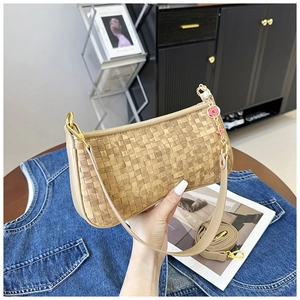 Detail of beige checkered woven baguette bag with a decorative pink floral metal chain