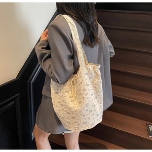 Detailed close-up of cream floral canvas tote bag with textured seersucker fabric finish