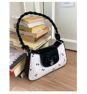 Détail de la poignée tressée noire et du motif papillon sur un sac rétro français
