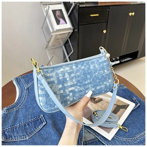 Close-up of a blue checkerboard baguette bag with pearl-accented gold chain strap