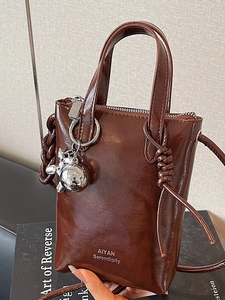Mini stylish brown glossy leather bucket bag with handle and silver rabbit charm pendant